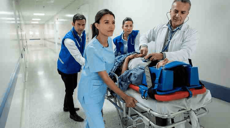 An emergency medicine resident and attending carrying a patient into the ER.